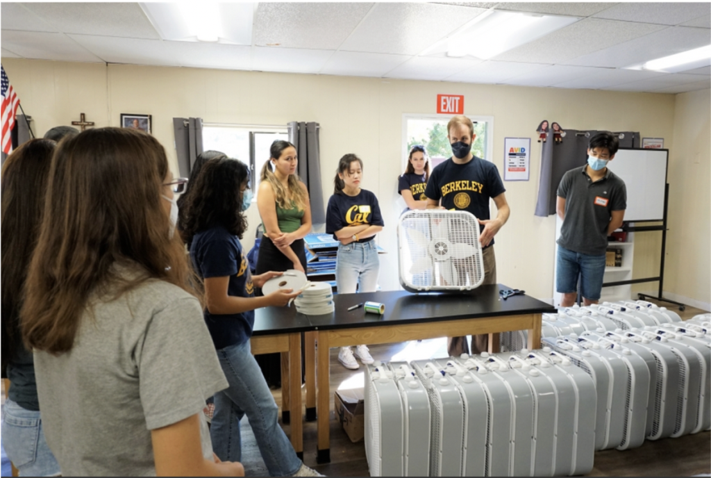 A Berkeley CEE student demonstrates how to build a homemade air purifier at All Saints Academy. (Photo Credit: Nia Jones)