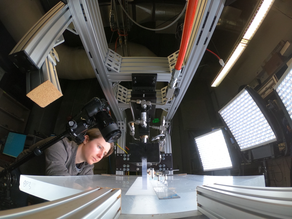 Person looking down at backlit table to examine particle samples.