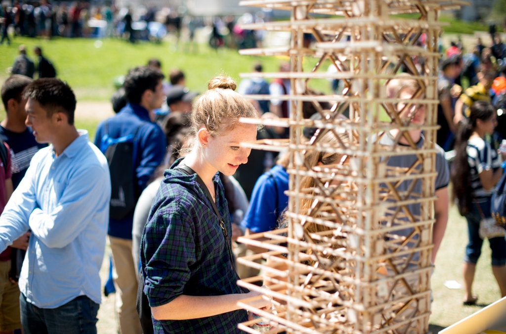 Woman views table with flyers and building model.