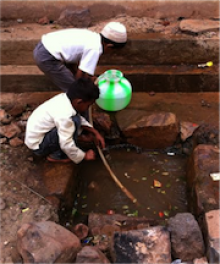 Boys collecting water from a submerged tap