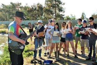 Professor Horne playing guitar and singing a treatment wetlands song he wrote to students of Professor David Sedlak, during a CEE field trip to Discovery Bay in 2015