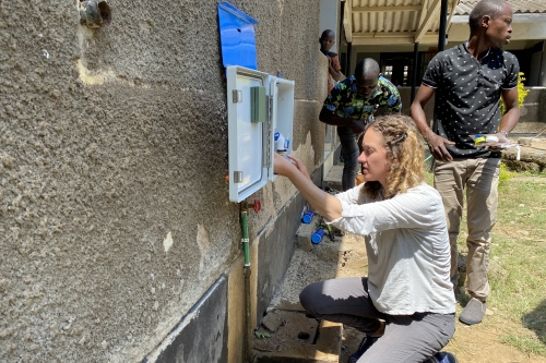 CEE Associate Proessor Amy Pickering installing a chlorine doser system. (Photo Credit: Amy Pickering)
