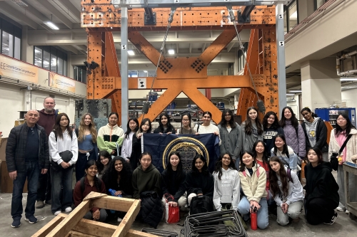 A group photo of SWE HSEP tour attendees and CEE lab staff Shakhzod Takhirov and Irik Larson at the Structures Lab on the second floor of David Hall (Photo Credit: Angie Wang).