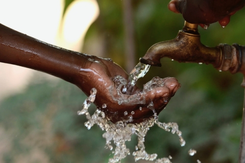 Close-up of a hand held under a stream of running water. (Photo Credit: iStock)