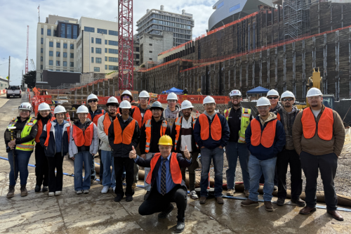 Students enrolled in CE 166 and Hensel Phelps workers pose in front of the UCSF Parnassus Research and Academic Building construction site.